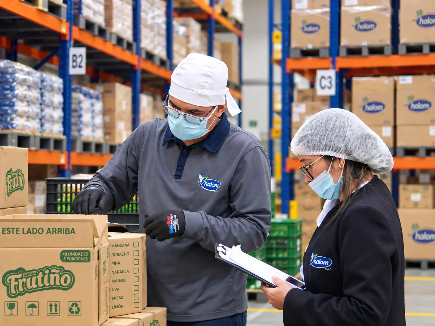 Personal de control de calidad revisando mercadería en el almacén